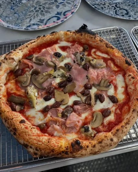 Pizza con funghi, olive nere di Gaeta e prosciutto cotto