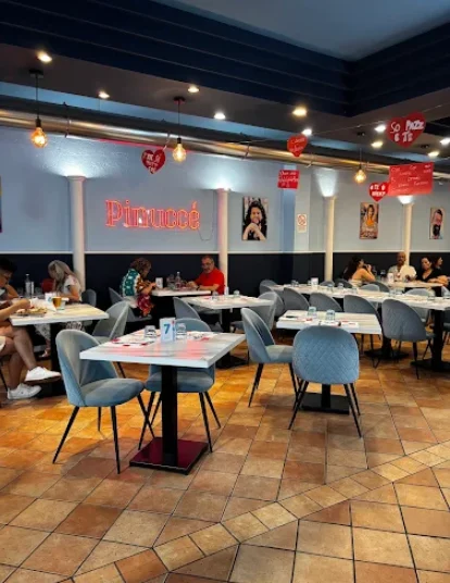 La sala di Pinuccé con l'insegna al neon e i tavoli in marmo